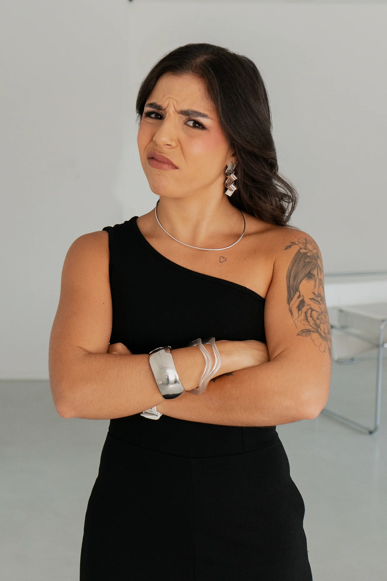 Bruna Vilaverde com expressão de dúvida, braços cruzados